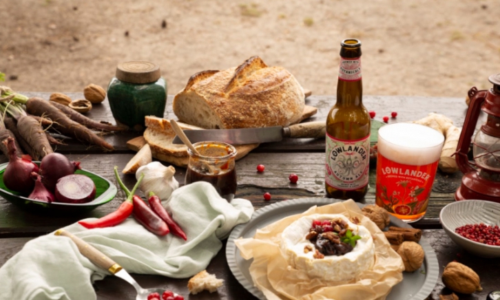 Lowlander Autumn Ale op tafel met eten er omheen